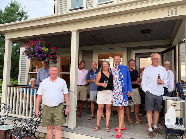 A group of people standing on a porch

Description automatically generated