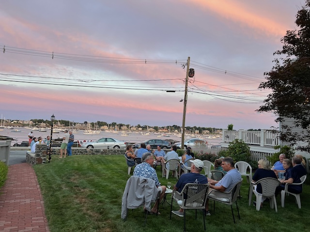 A group of people sitting in chairs outsideDescription automatically generated