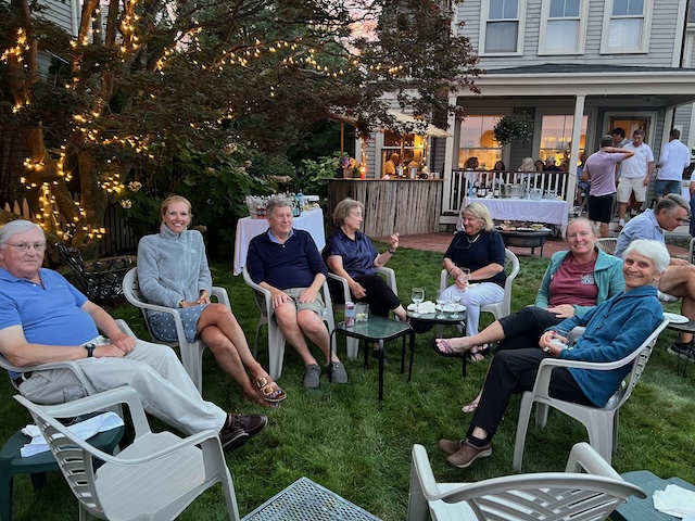 A group of people sitting in chairs outsideDescription automatically generated