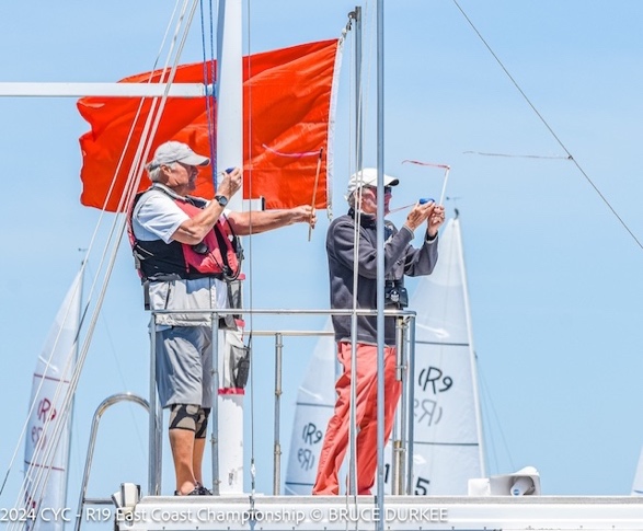 Men on a boat with a flagDescription automatically generated