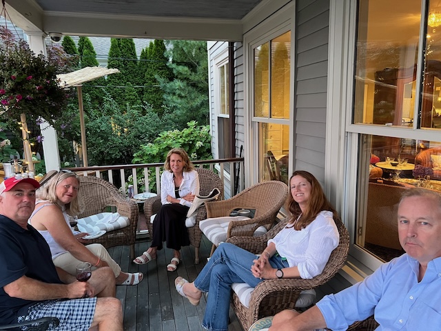 A group of people sitting on a porchDescription automatically generated