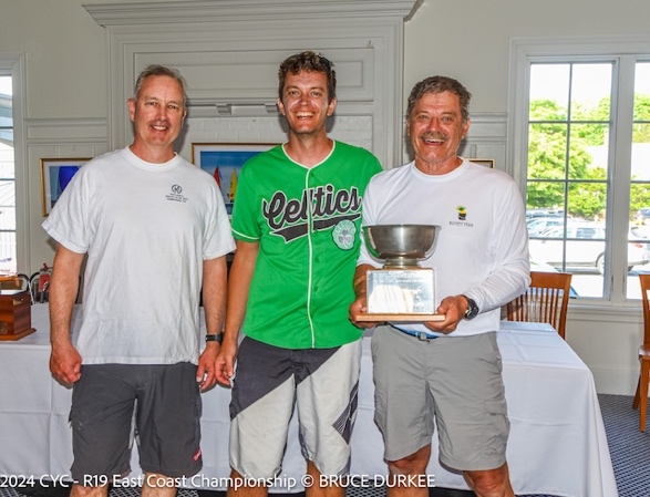 A group of men standing next to a trophyDescription automatically generated