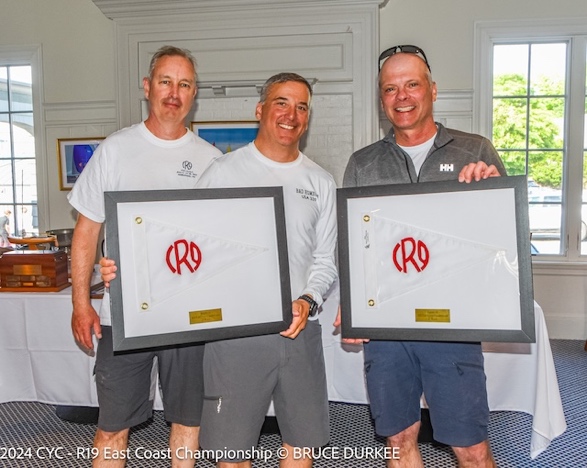 A group of men holding up framed certificatesDescription automatically generated