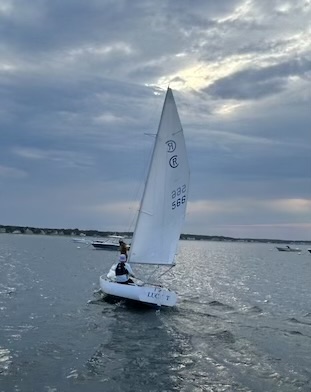 A person on a sailboat in the waterDescription automatically generated