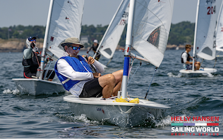 A person in a blue life jacket on a small sailboatDescription automatically generated