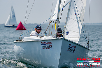 A couple of men sailing on a boatDescription automatically generated